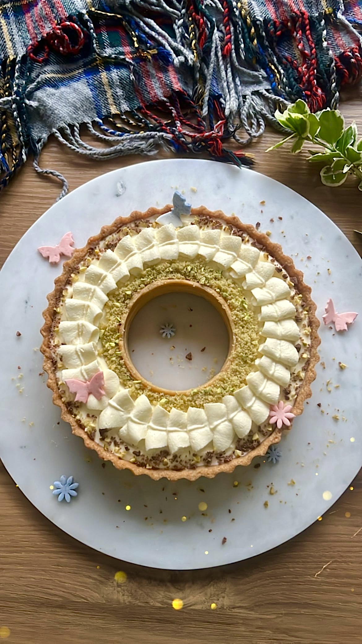 Tart ring topped with ribbon-shaped cream, decorated with butterfly-shaped sugar toppers.